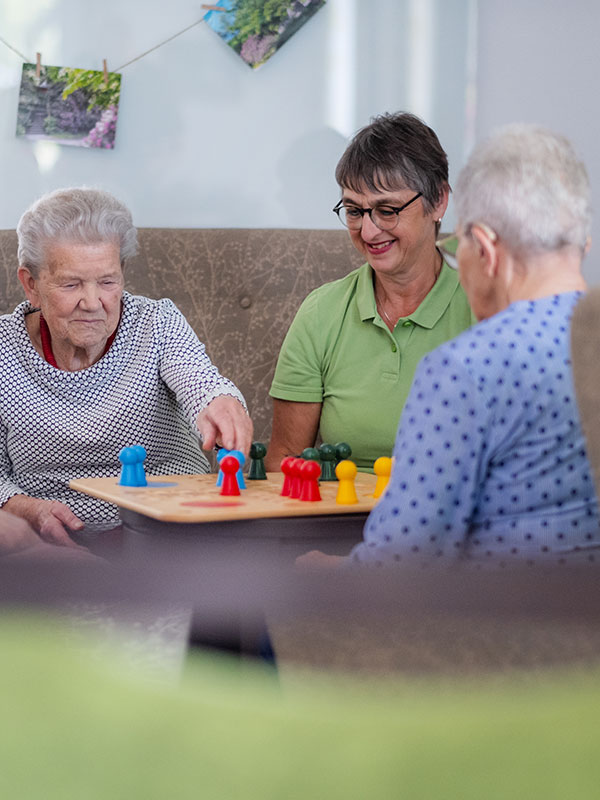 Eine Mitarbeiterin der Tagespflege mit einem Gast beim Spielen